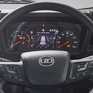 Truck dashboard with warning lights and a digital display behind the steering wheel.