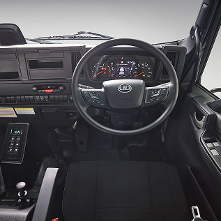 Truck dashboard and steering wheel, black interior, digital and analogue gauges.