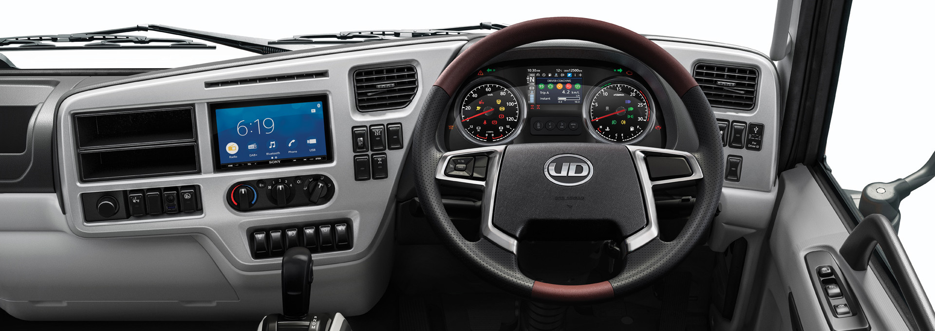 Dashboard truk modern dengan setir, panel instrumen, dan layar digital berwarna biru.
