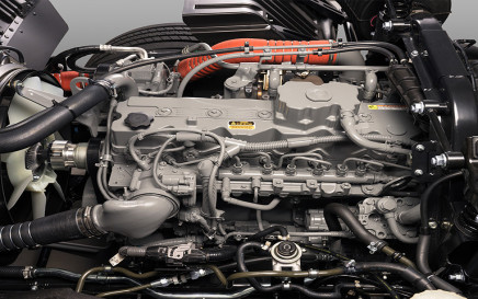 Close-up of a grey car engine with various pipes and cables.