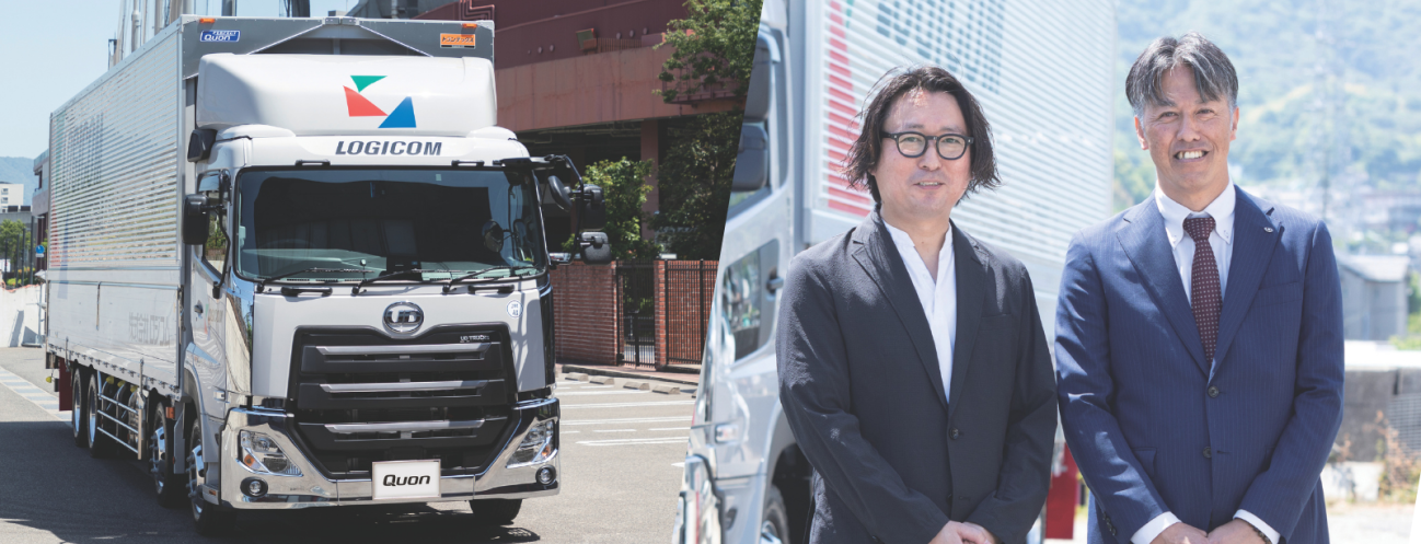 大型トラックとスーツ姿の男性二人が屋外で並んでいる