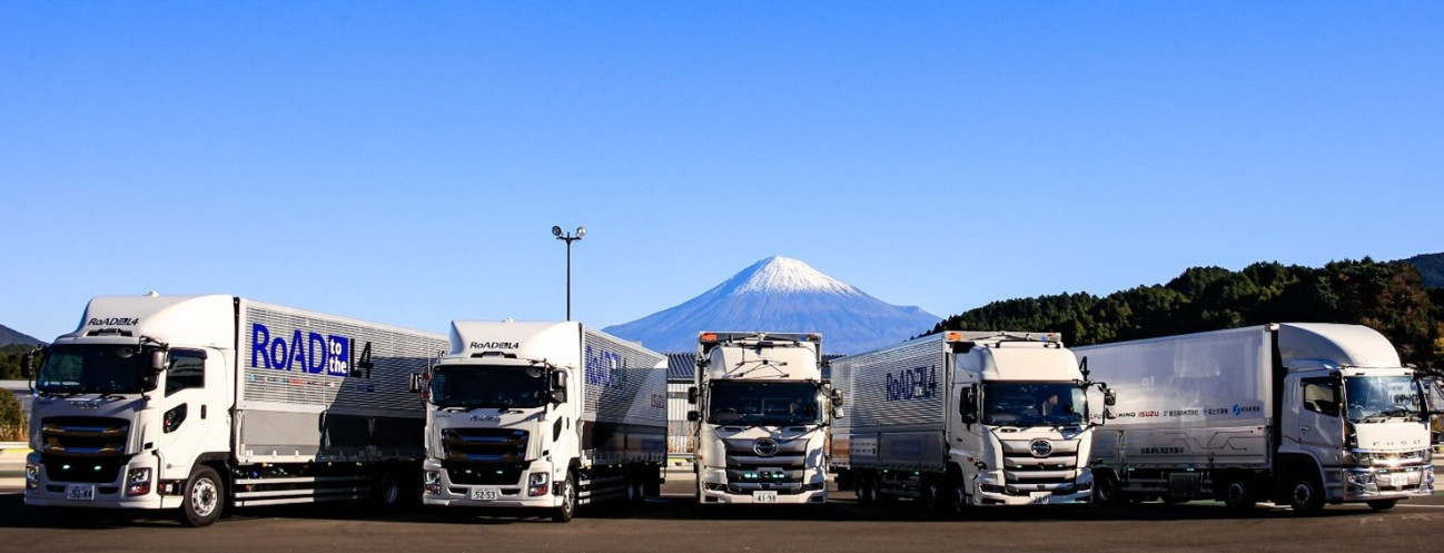 富士山を背景に並ぶ5台の銀色トラック