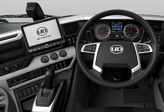 Modern vehicle dashboard with steering wheel, digital screens, and control buttons.