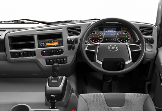 Dasbor truk modern dengan setir, panel instrumen, dan tuas transmisi.