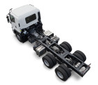 White truck chassis with no cargo body, six large wheels, on white background.